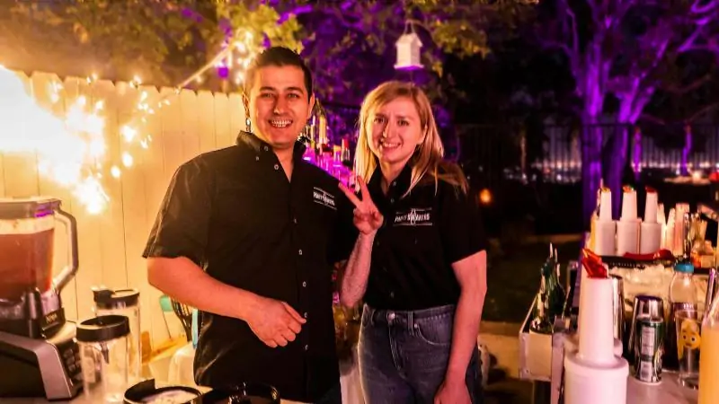 Is bartending an emotional profession? Male and female bartenders behind a bar. Both smiling and emotionally stable