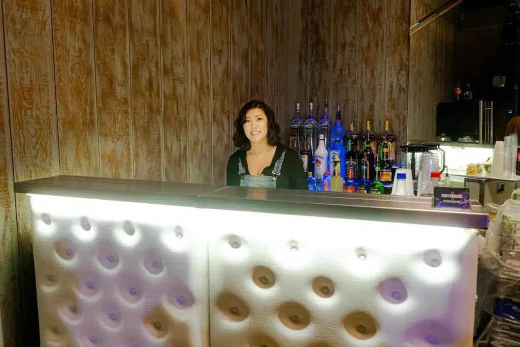 A female bartender behind a bar | bartenders to hire